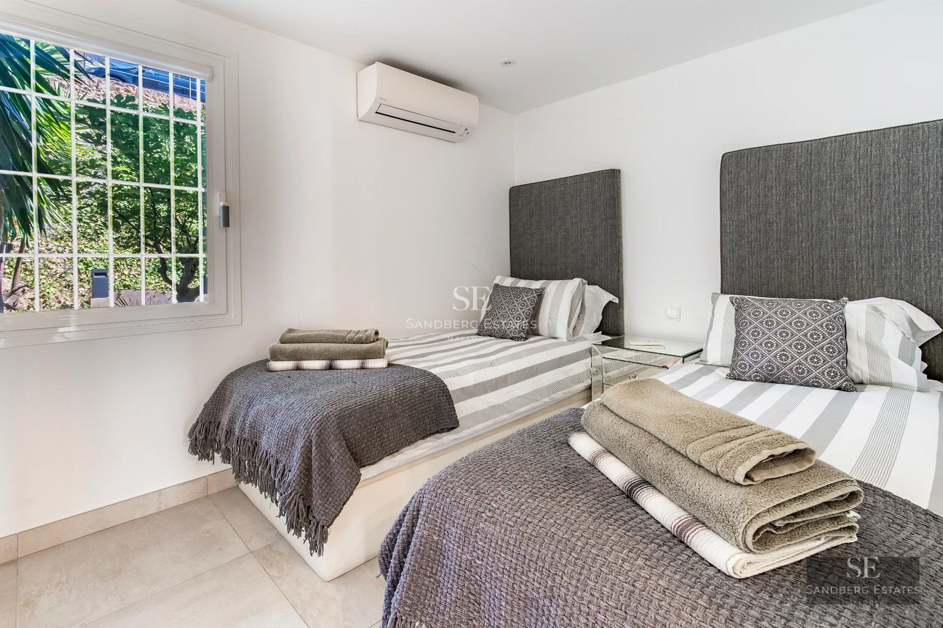 Aerial view of modern villa with infinity pool, expansive garden, minimalist architecture, and bright panoramic windows.