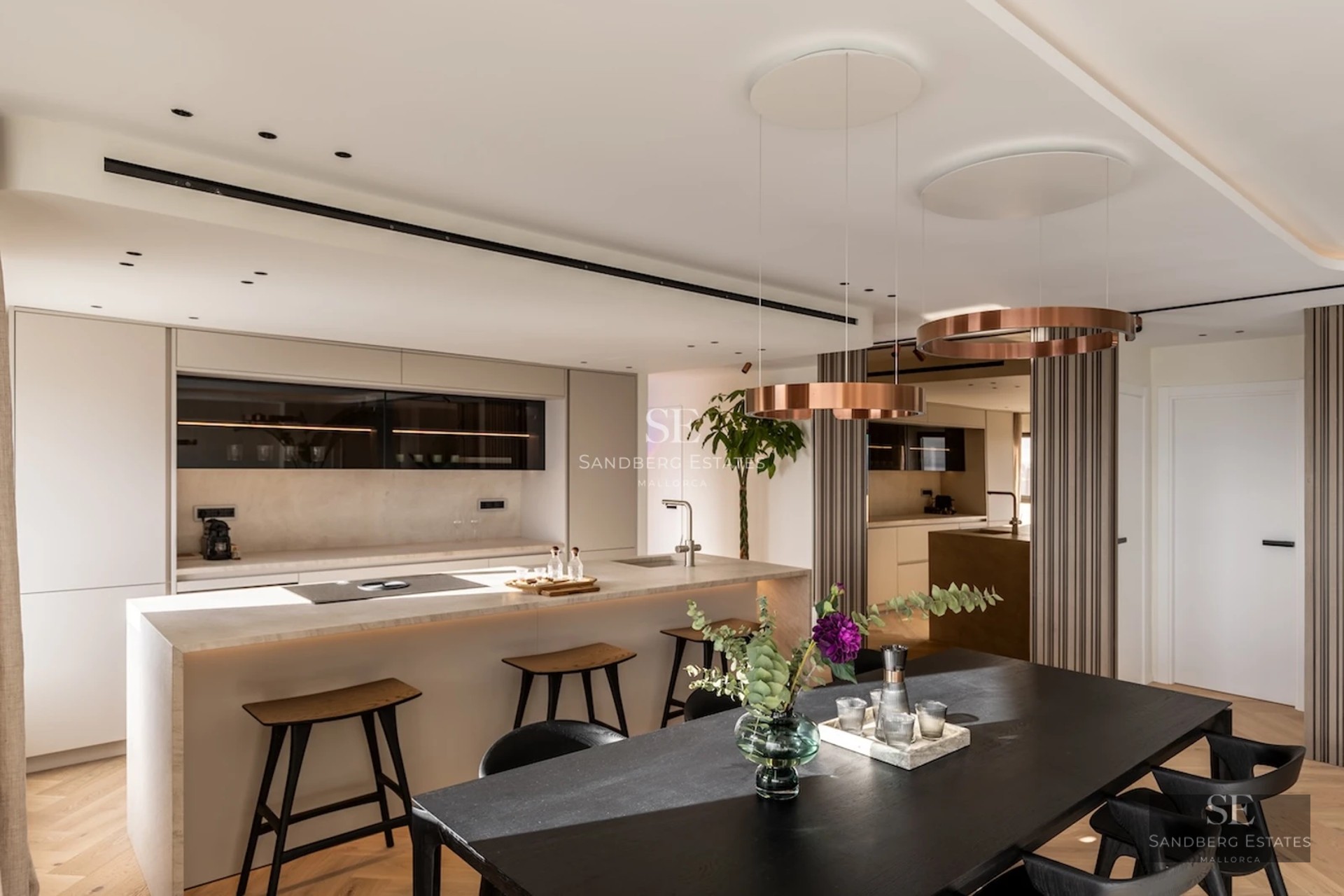 View of the infinity pool from the terrace. Modern design with sun loungers, umbrellas, and lush greenery. Elegance and comfort.