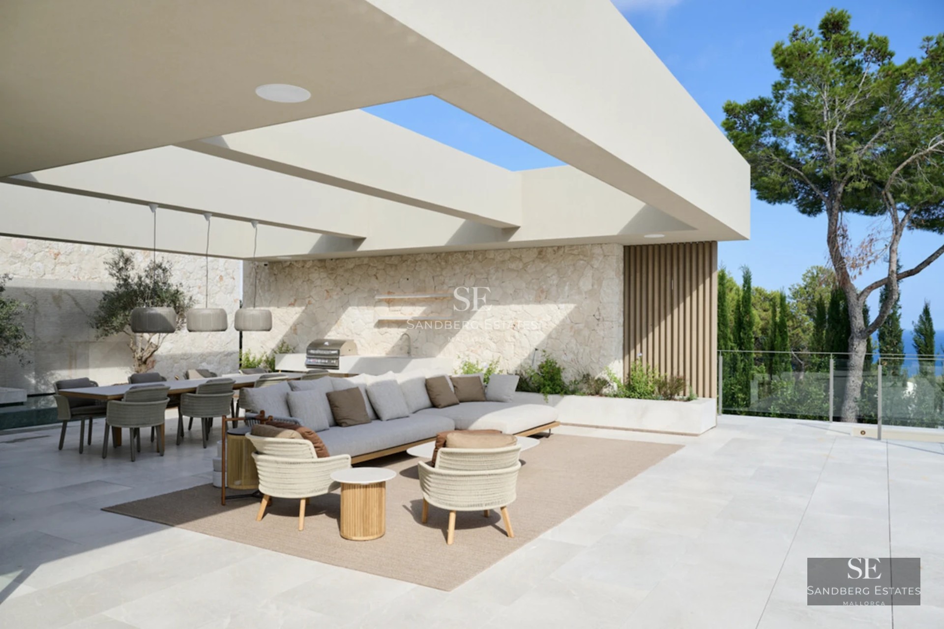 Expansive terrace with infinity pool, ocean views. Modern designer furniture, lush landscaping. Warm ambient lighting.