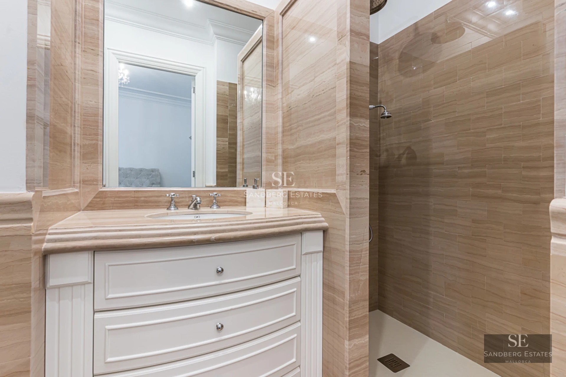 Spacious living room with floor-to-ceiling windows, natural light, light wood floors, and modern furniture. View of the garden with pool.