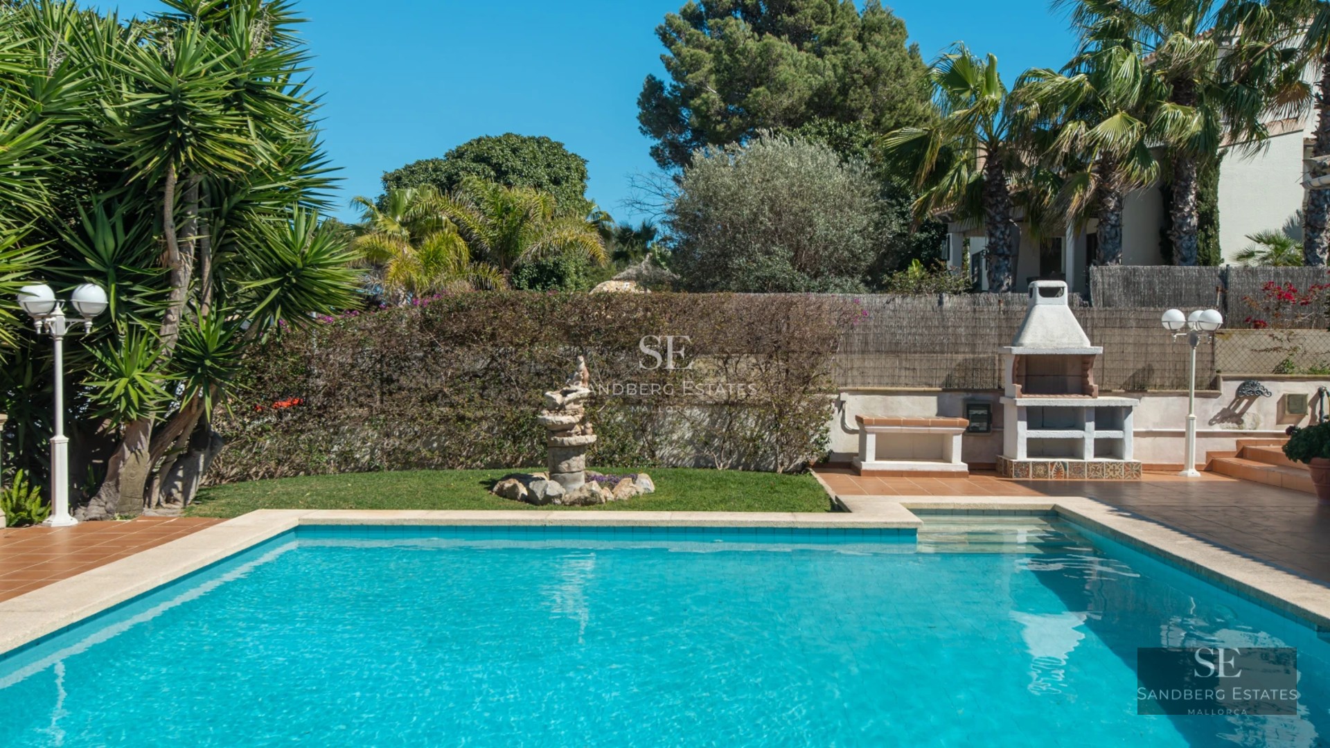 Large balcony with sea view. Modern design, glass railing, wooden floor. Soft lighting and elegant furniture.