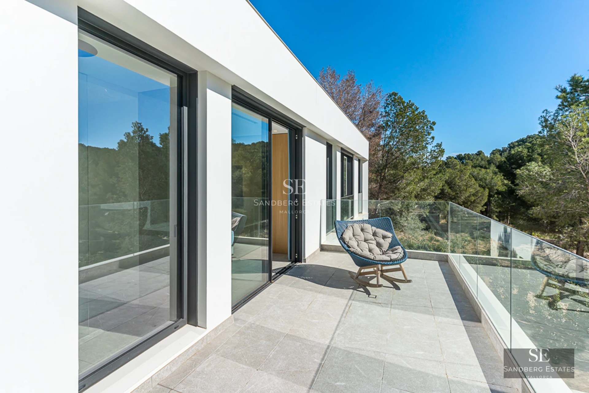 Vue extérieure d'une villa moderne avec piscine. Architecture minimaliste, grandes fenêtres et aménagement paysager luxuriant.