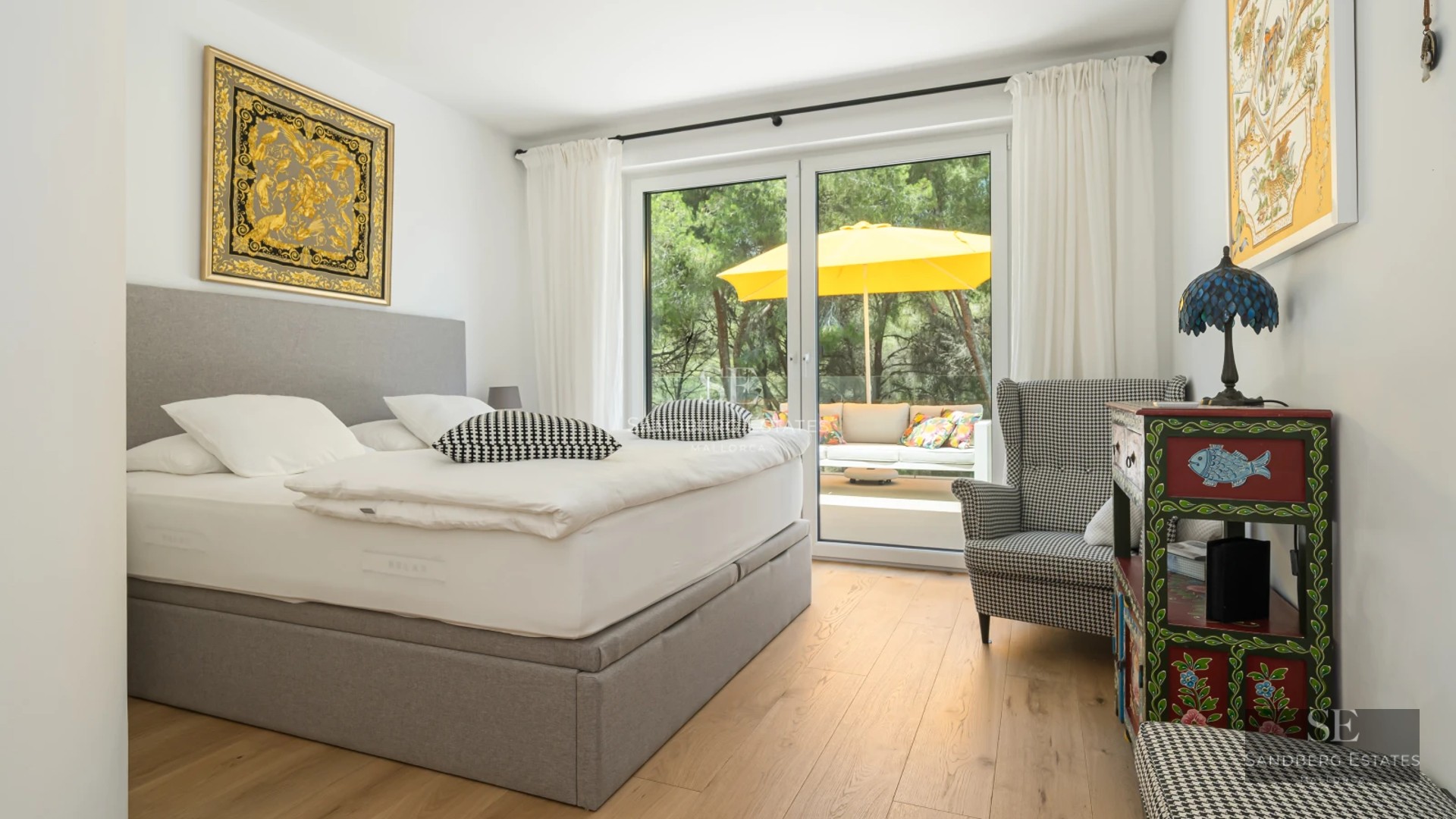 Spacious living room with balcony and sea view. Modern furniture, light wood floors, and abundant natural light.