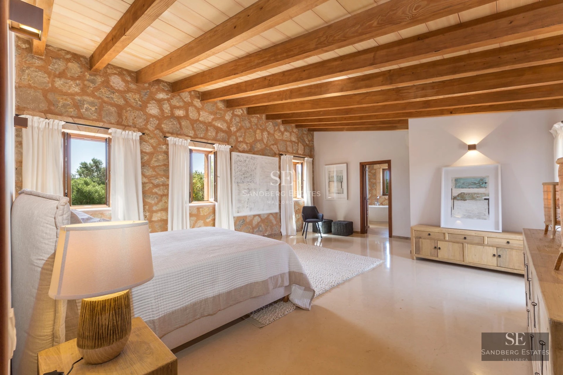 Modern living room with large windows, sea view, and stylish furniture. Light wood floors and private terrace.