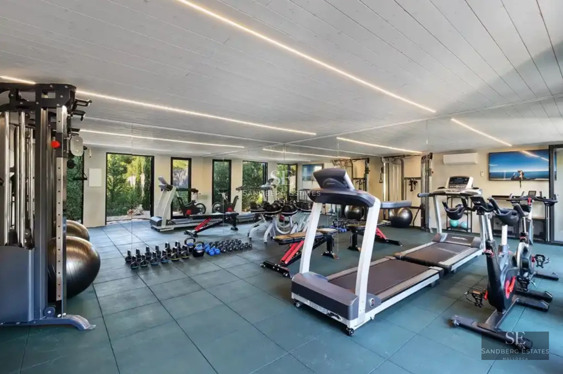 Spacious living room with panoramic sea views, modern sofas, textured rug, and soft ambient lighting.
