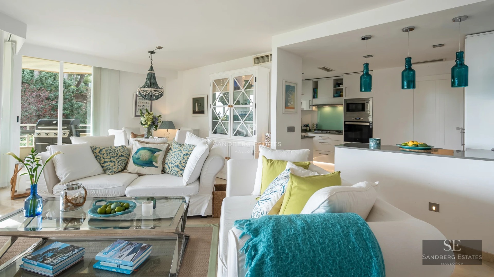 View of an infinity pool with lounge chairs and a modern house featuring large windows and a lush garden in the background.