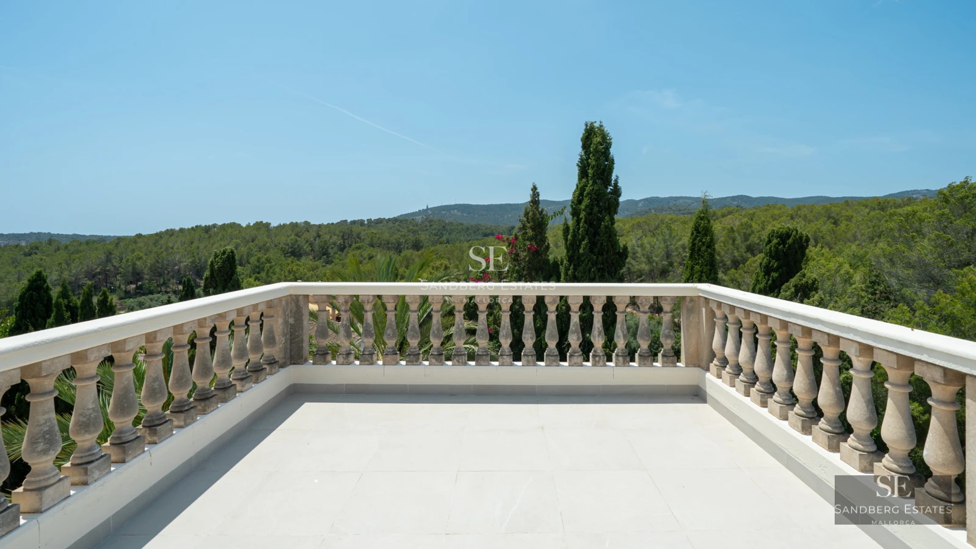 Spacious living room with floor-to-ceiling windows, light wood flooring, modern gray sofas, coffee table, and balcony access with sea view.