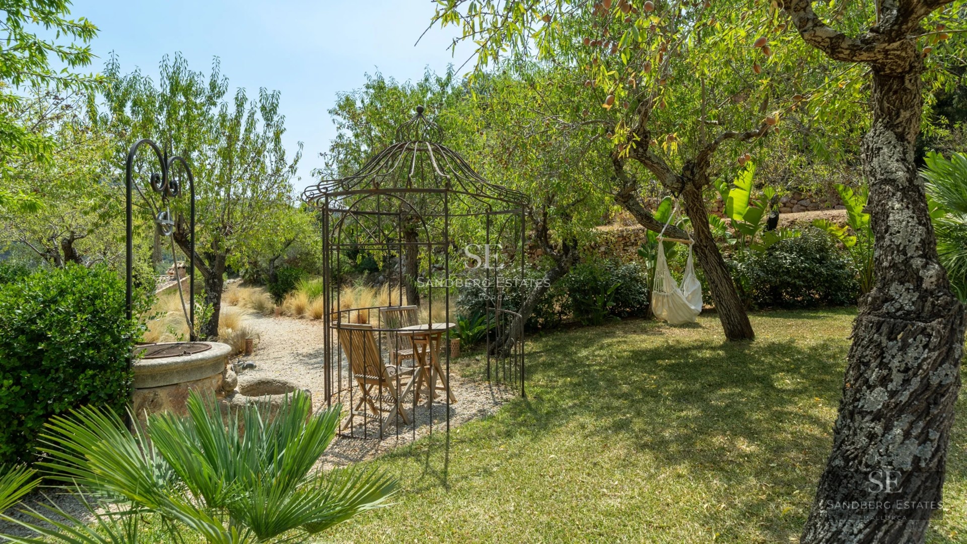 View of an elegant infinity pool overlooking the sea, surrounded by a modern terrace with sun loungers and lush vegetation.