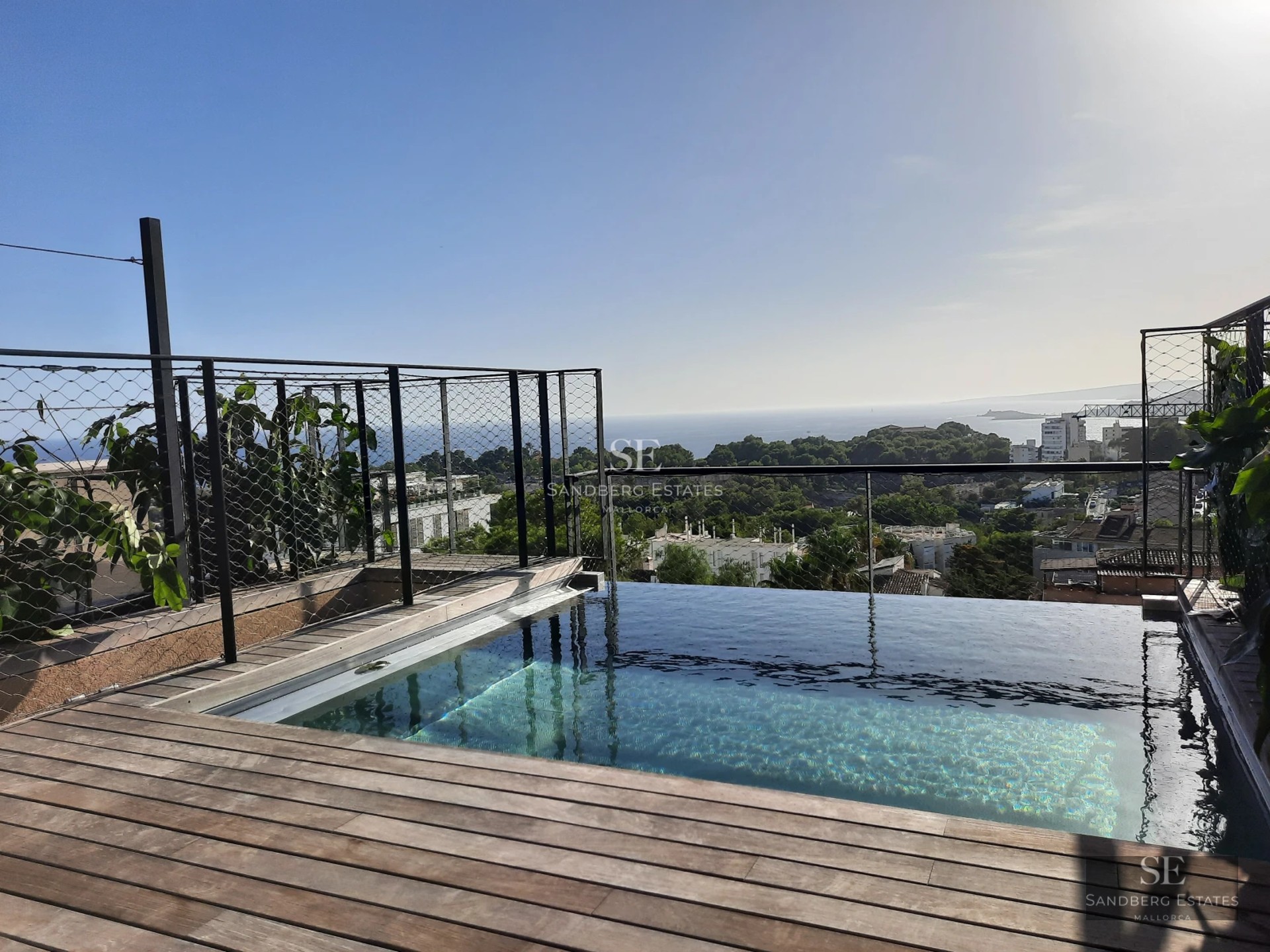 Spacious terrace with infinity pool and panoramic views. Modern architecture with clean lines and large windows.