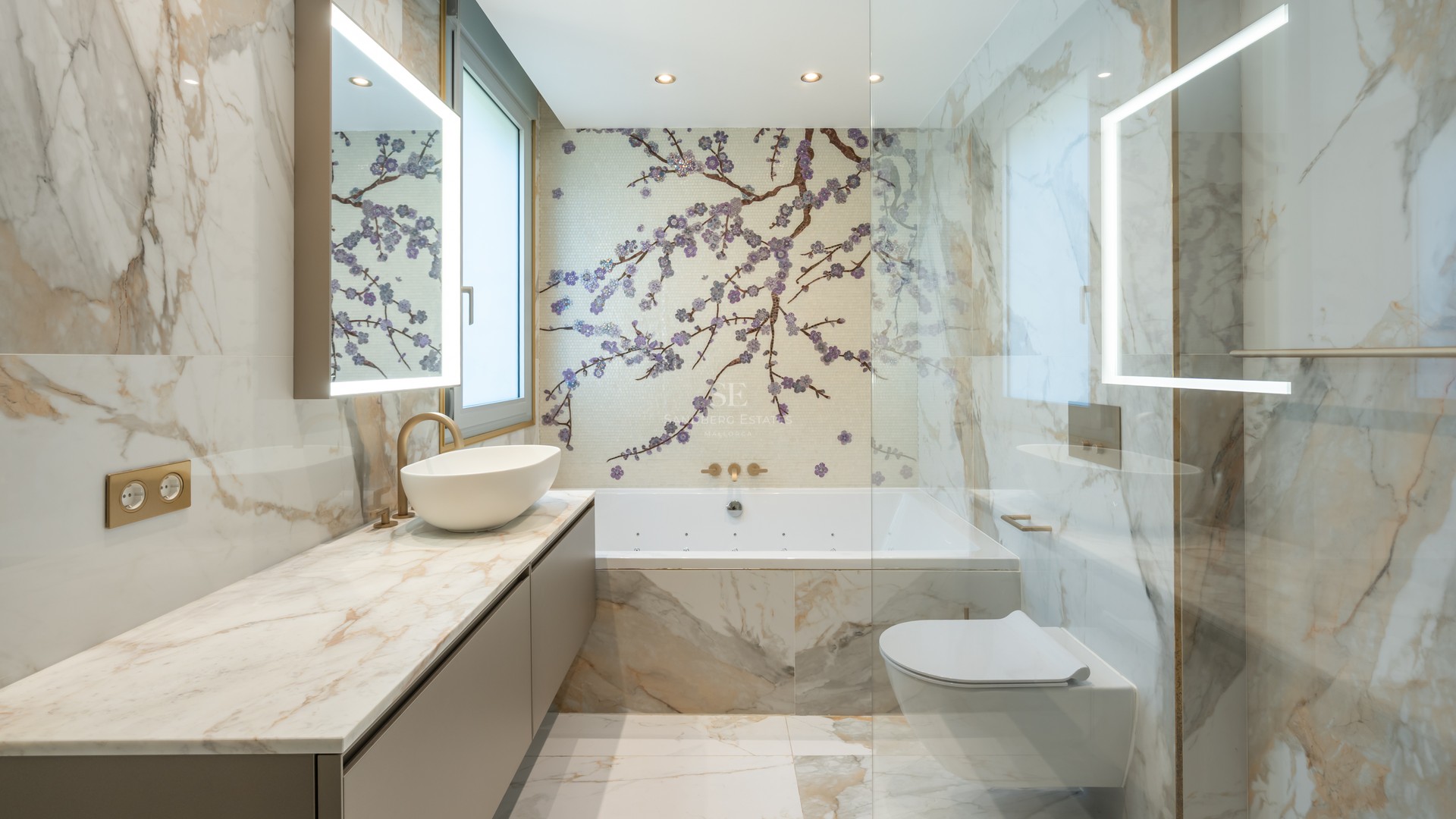 Luxury bathroom featuring Calacatta marble walls, a cherry blossom mosaic feature wall, and backlit LED mirrors.
