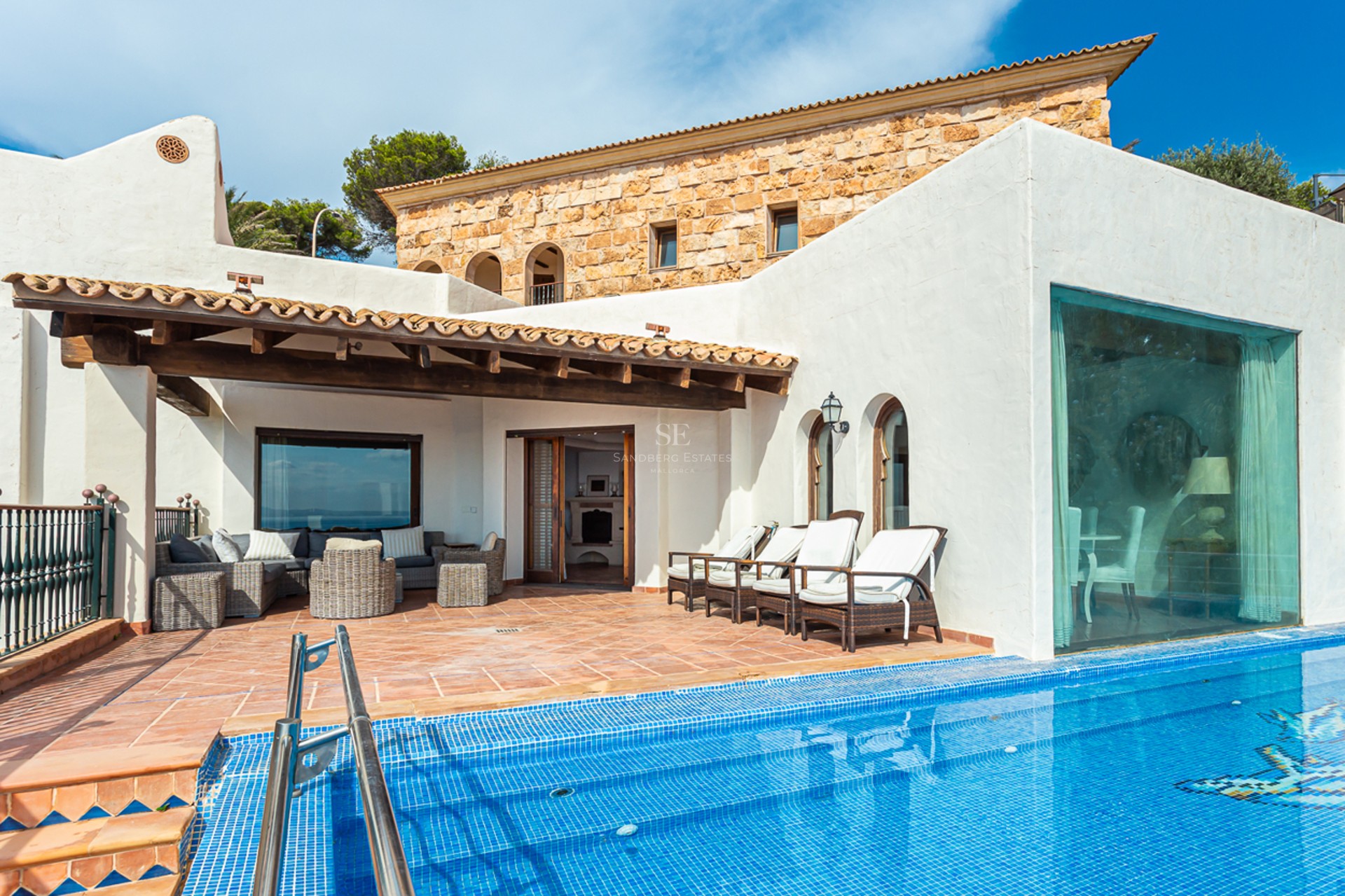 Vaste terrasse avec piscine à débordement et vue panoramique. Design moderne, mobilier d'extérieur élégant et végétation luxuriante.