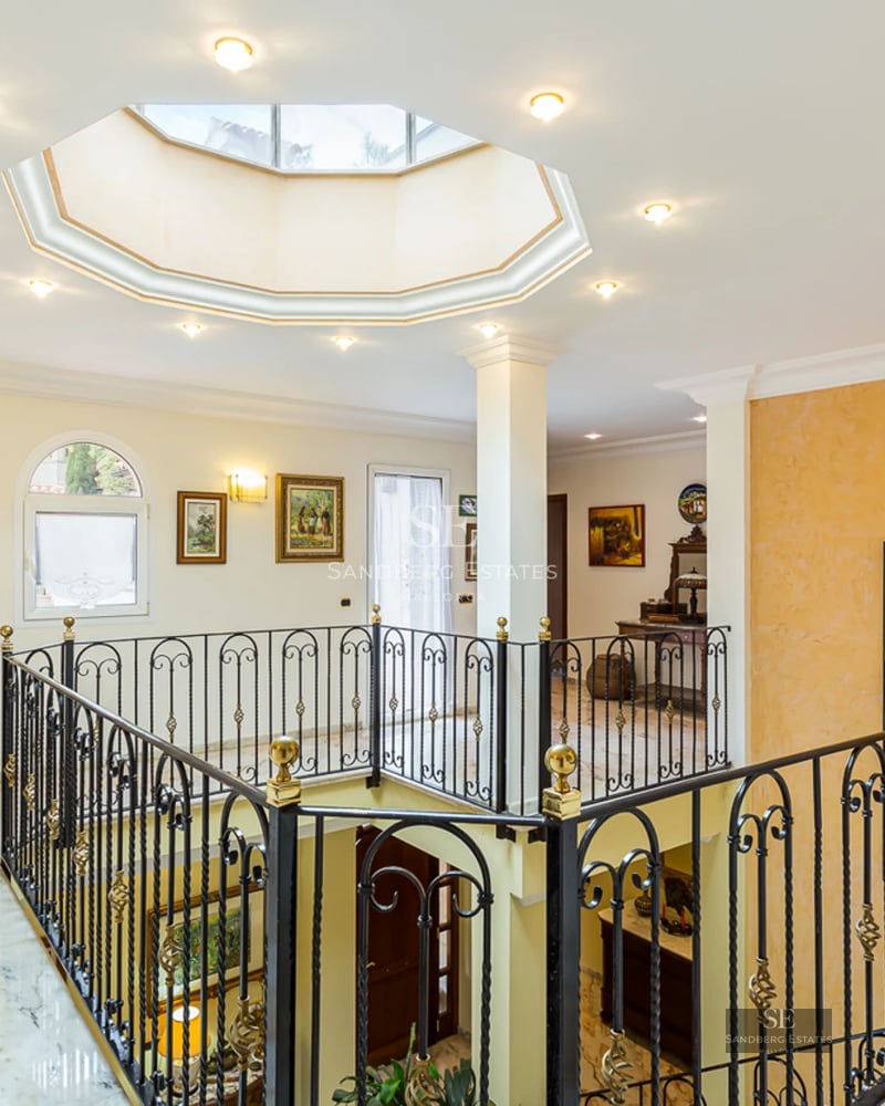 Bright apartment with sea view. Large windows, balcony with glass railing and modern furniture. Sleek and minimalist design.