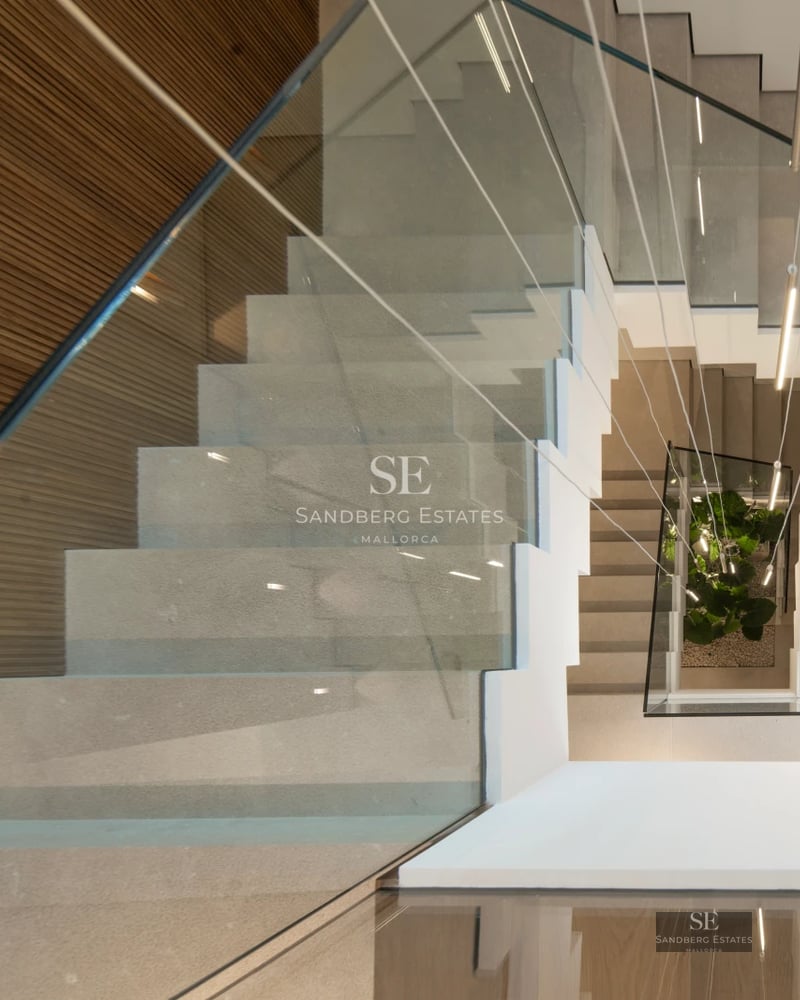 View of modern property with reflective pool and lush garden. Minimalist architecture and large windows.