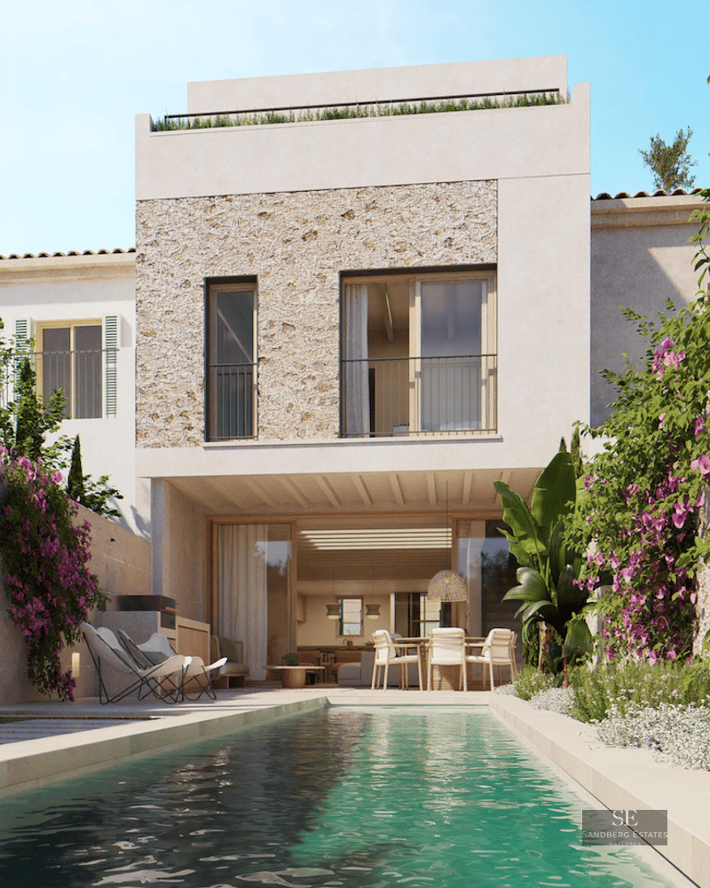 A lap pool in front of a modern white villa with natural stone cladding and vibrant bougainvillea flowers.