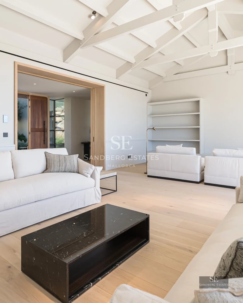 Aerial view of luxury property with infinity pool, lush garden, and modern architectural design. Ambient lighting.