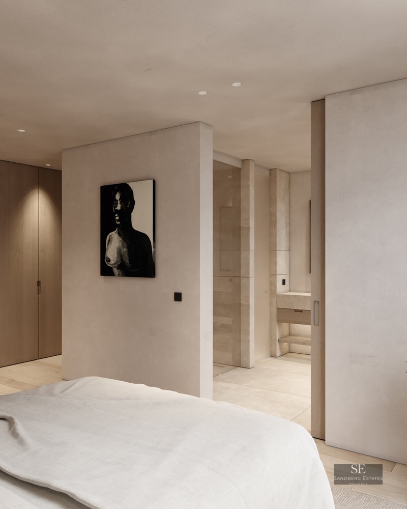 Modern bedroom featuring wood closets, beige walls, and a view into a private ensuite bathroom with stone finishes.