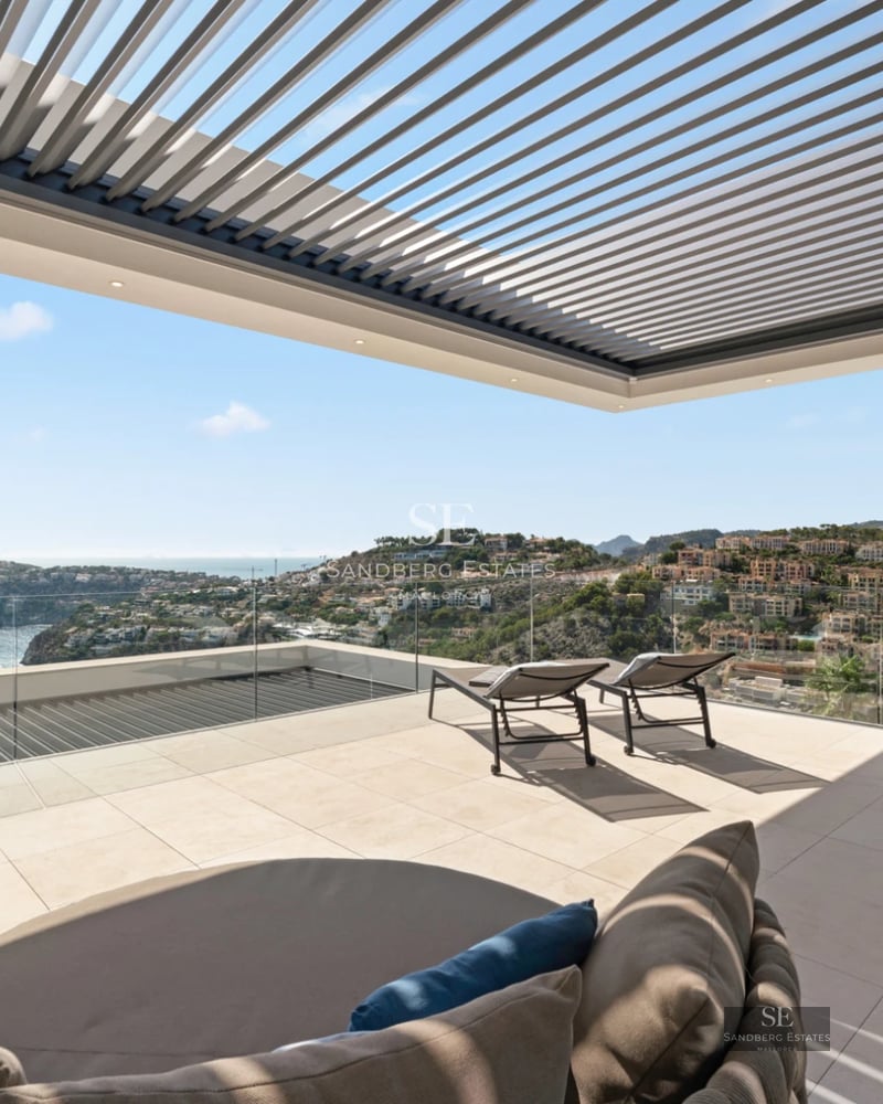 Spacious living room featuring floor-to-ceiling windows, reflecting pool, and minimalist design. Luxurious interior with natural light.
