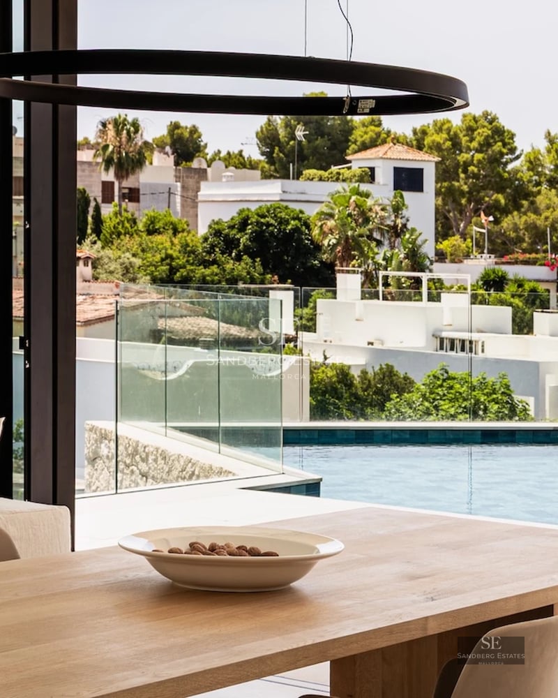 Spacious exterior featuring a modern pool, covered seating area, and lush gardens. Contemporary design and high-quality materials.