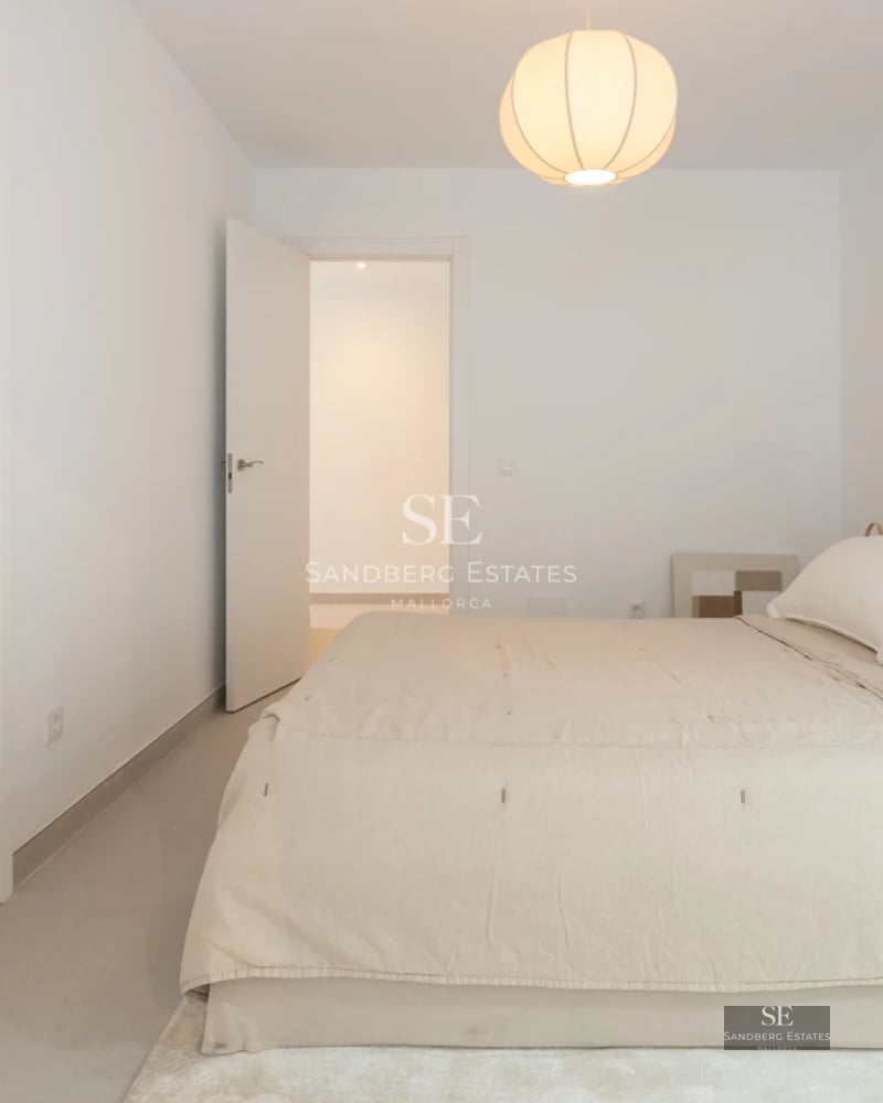 Spacious balcony with sea view. Modern design with glass railing, outdoor furniture, and wooden flooring.