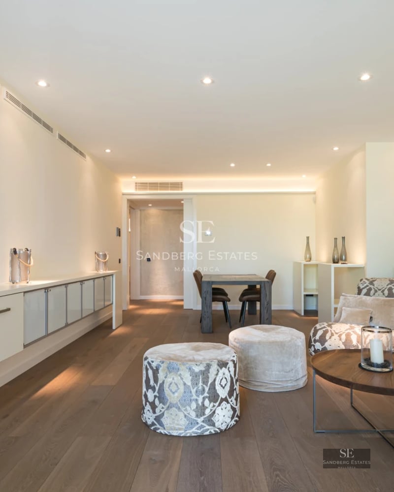 Bright living room with balcony and sea view. Modern design, light wood floors, and elegant furniture.
