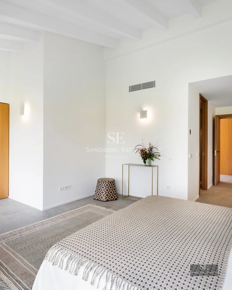 View of luxurious villa with reflective pool. Modern design, large windows, and manicured landscaping. Clear blue sky.