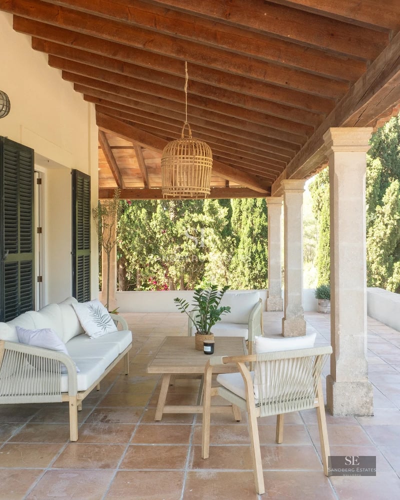 Wide view of a pool bordered by a manicured garden and a modern villa with minimalist design. Natural lighting.