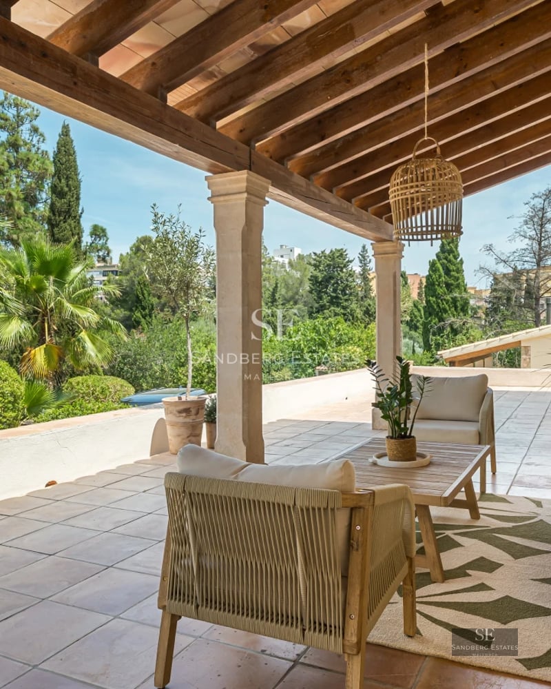 Aerial view of a luxury home with infinity pool, immaculate garden, spacious terrace and modern architectural design.