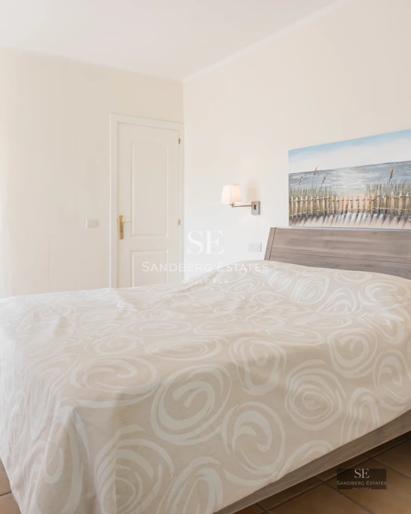 Spacious living room with large windows, modern furniture, and access to balcony with sea view. Natural lighting.