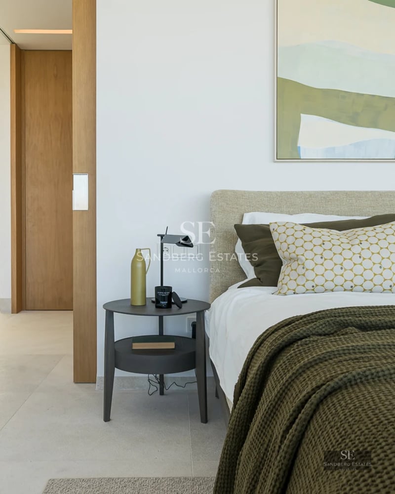 Spacious living room with large windows, modern fireplace, and garden view. Designer furniture and abundant natural light.