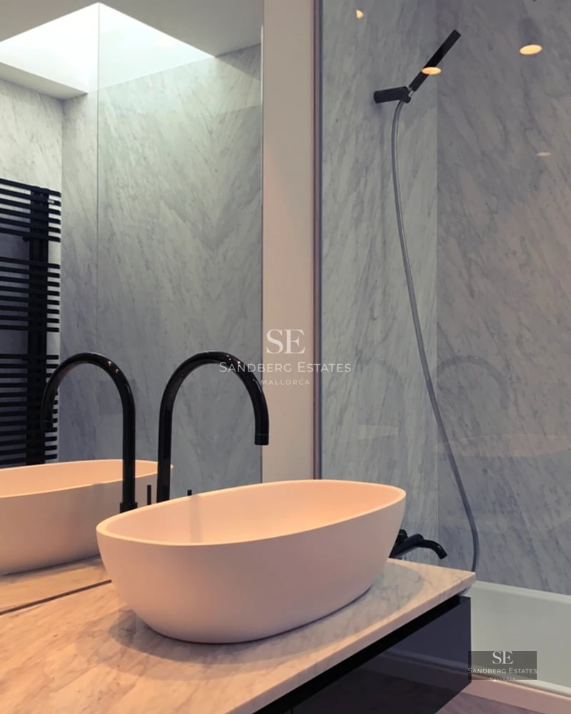 Panoramic view of a modern infinity pool, with lounge chairs and lush vegetation. Clean and sophisticated architectural design.