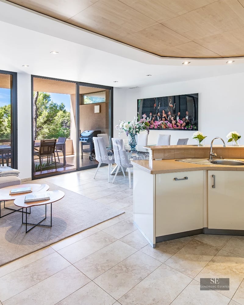 View of modern villa with infinity pool. Minimalist architecture, large windows, and lush natural environment.