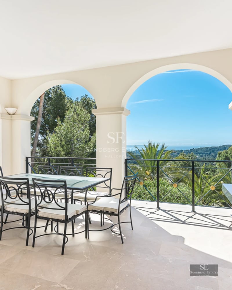 Spacious balcony with panoramic views. Glass railing and wooden floors. Soft lighting. Ideal space for relaxation.