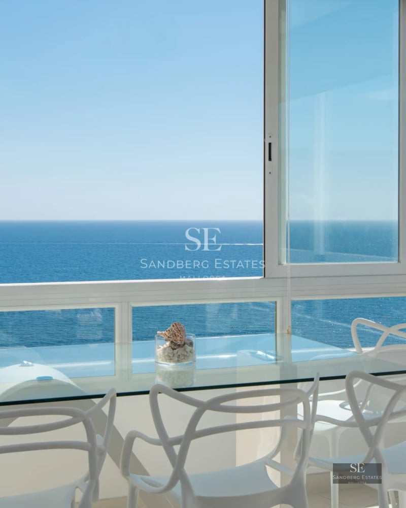 Spacious living room with panoramic windows. Light wood floors, modern fireplace, and designer furniture. Views of greenery.