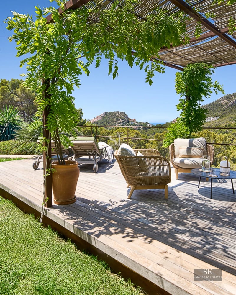 Spacious living room with large windows, sea view, light wood flooring, and modern furniture in neutral tones.