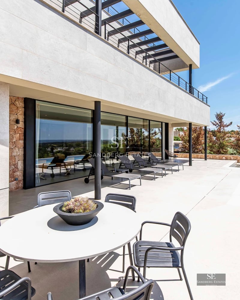 Spacious balcony with sea view. Modern outdoor furniture and glass railing. Bright and open space, ideal for relaxing.