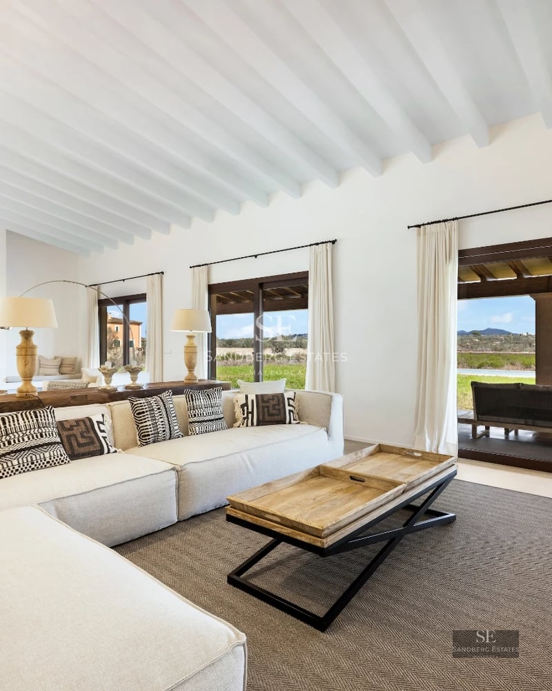 Spacious living room featuring panoramic windows, light wood flooring, and stunning ocean views. Modern and bright design.