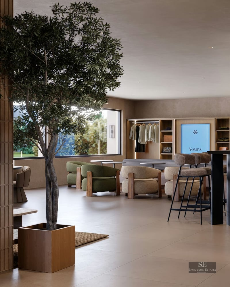 Hall moderne avec un arbre d'intérieur, des fauteuils vert olive, des piliers carrelés et de grandes fenêtres.