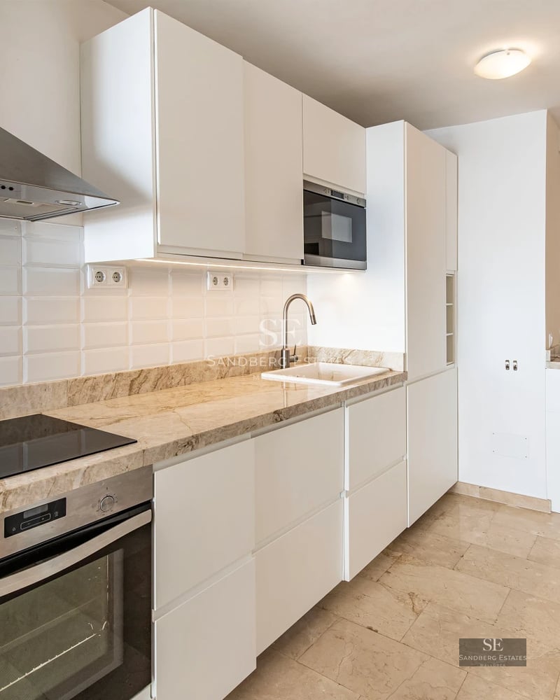 View of infinity pool with loungers, modern architecture, and gardens. Luxurious house with large windows and soft lighting.