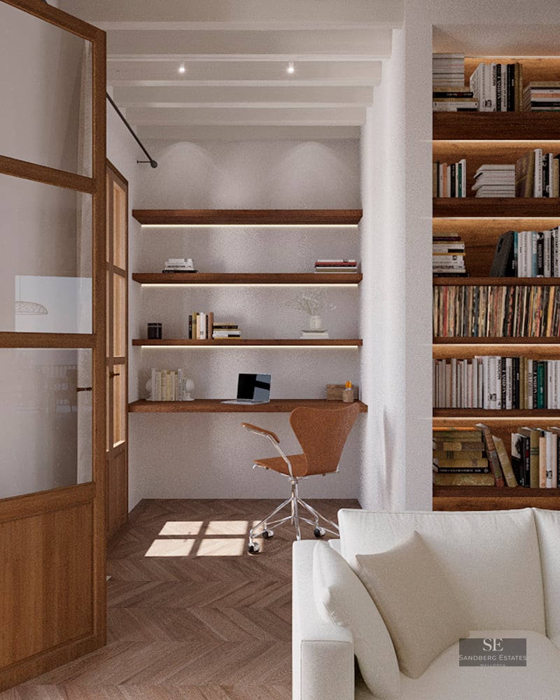 Modern home office nook featuring a wooden desk, floating shelves, and a large built-in bookshelf next to a white sofa.