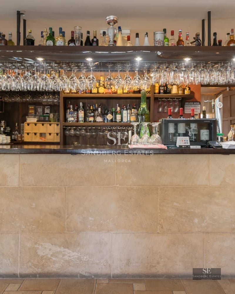 Spacious balcony overlooking the sea and pool. Modern design with glass railing and stylish furniture. Natural lighting and neutral colors.