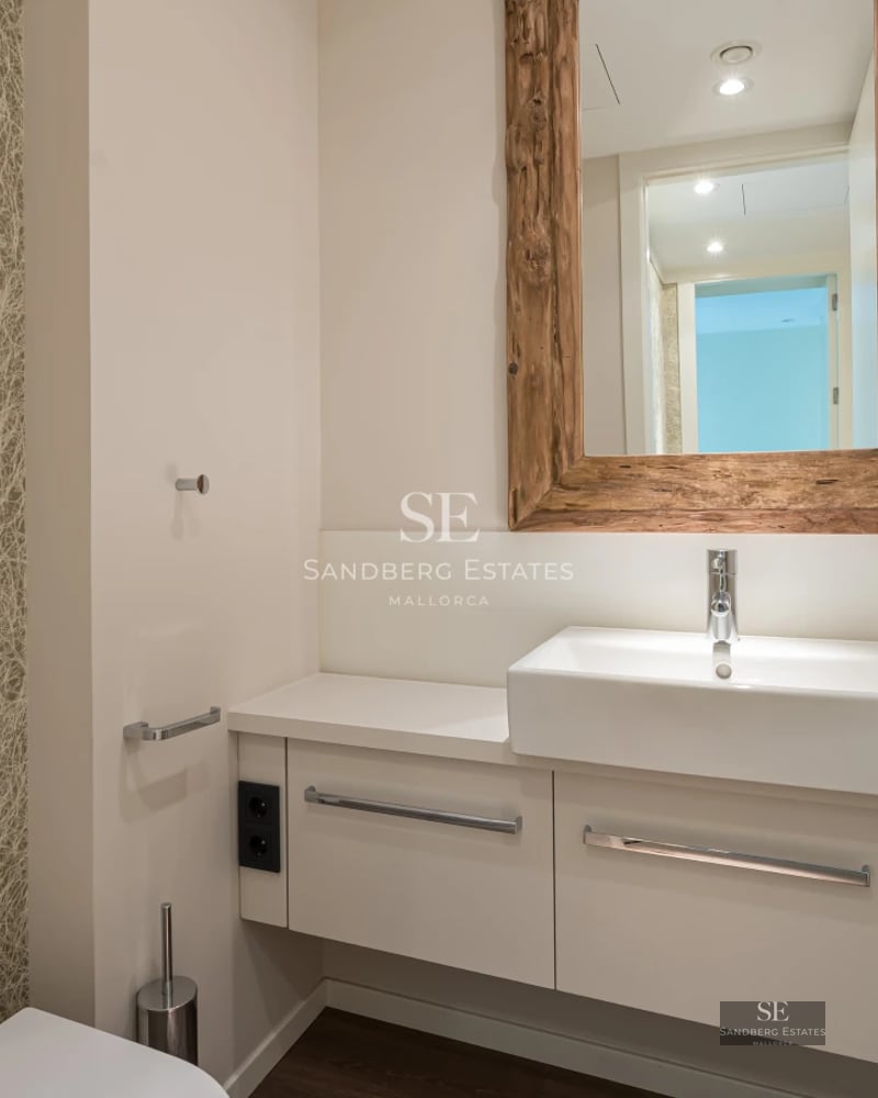 Modern balcony featuring glass railings, sea views, stylish furniture, and wooden flooring. Soft lighting and relaxing ambiance.