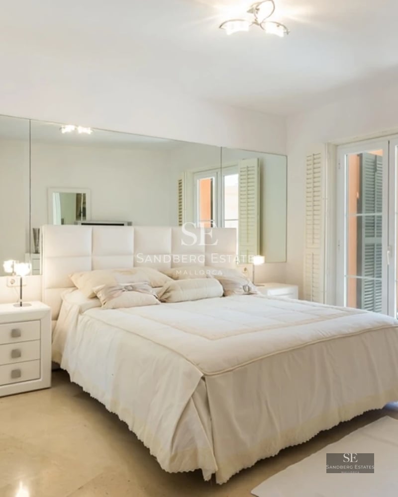 View of the pool, garden, and modern facade of a villa. Clean lines, large windows, and lush vegetation.