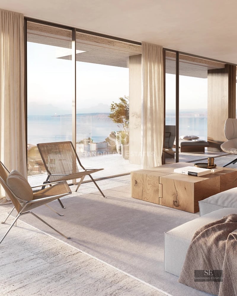 Spacious living room with panoramic windows, modern sofas, textured rug and sea views. Natural lighting and minimalist design.