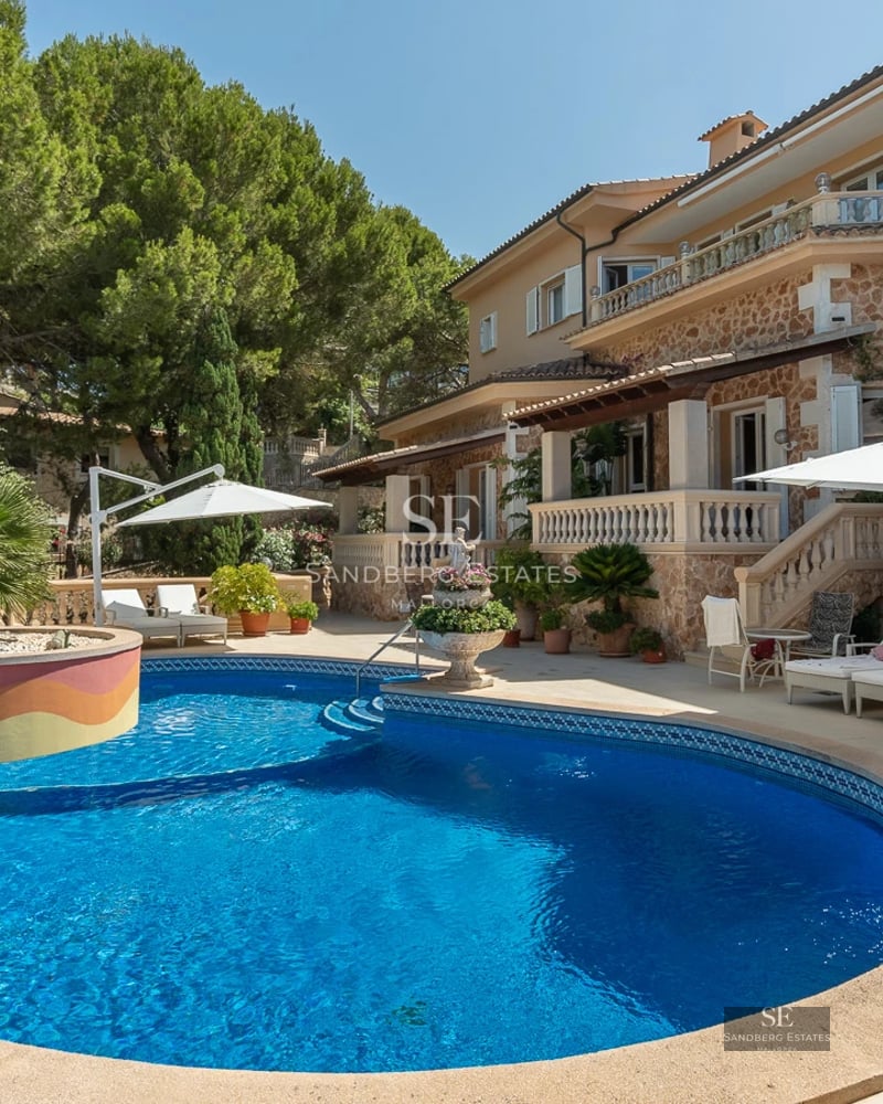 Exterior view of a modern villa with a pool, garden, and minimalist architecture. Natural stone facade and large windows.