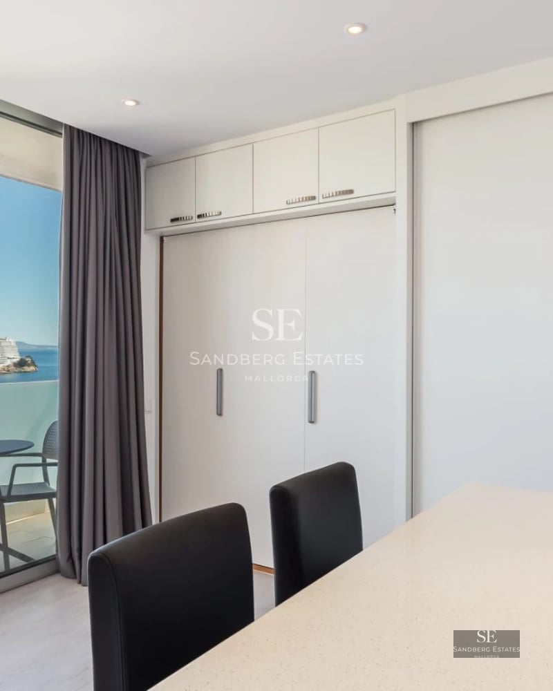 Spacious balcony with sea views, glass railing, modern furniture, and wooden floor. Minimalist and elegant design.