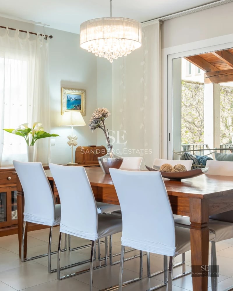 Spacious living room with large windows, panoramic views, light wood flooring, and modern furniture. Abundant natural light.