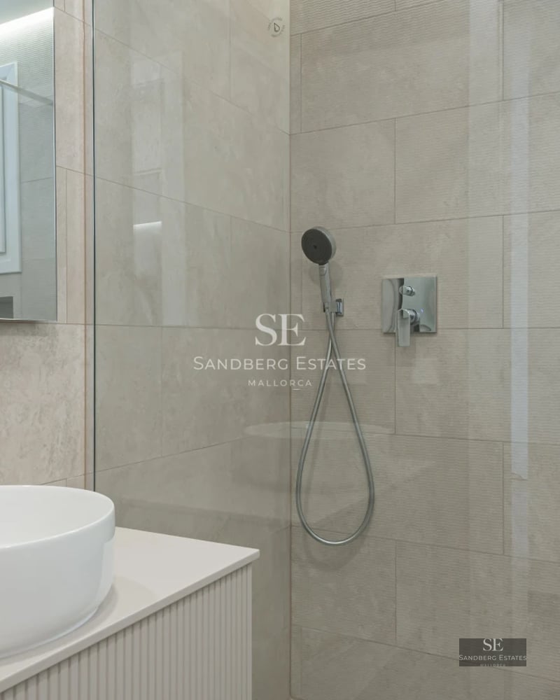 Spacious living room with floor-to-ceiling windows, wood floors, modern furniture, and a stunning ocean view. Luxurious and bright.