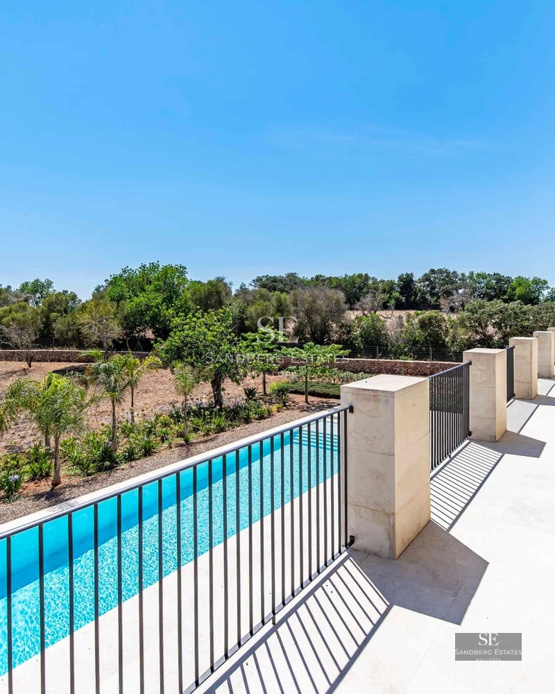 Exterior view of a modern villa with infinity pool, sun loungers and lush greenery. Minimalist architecture with large windows.