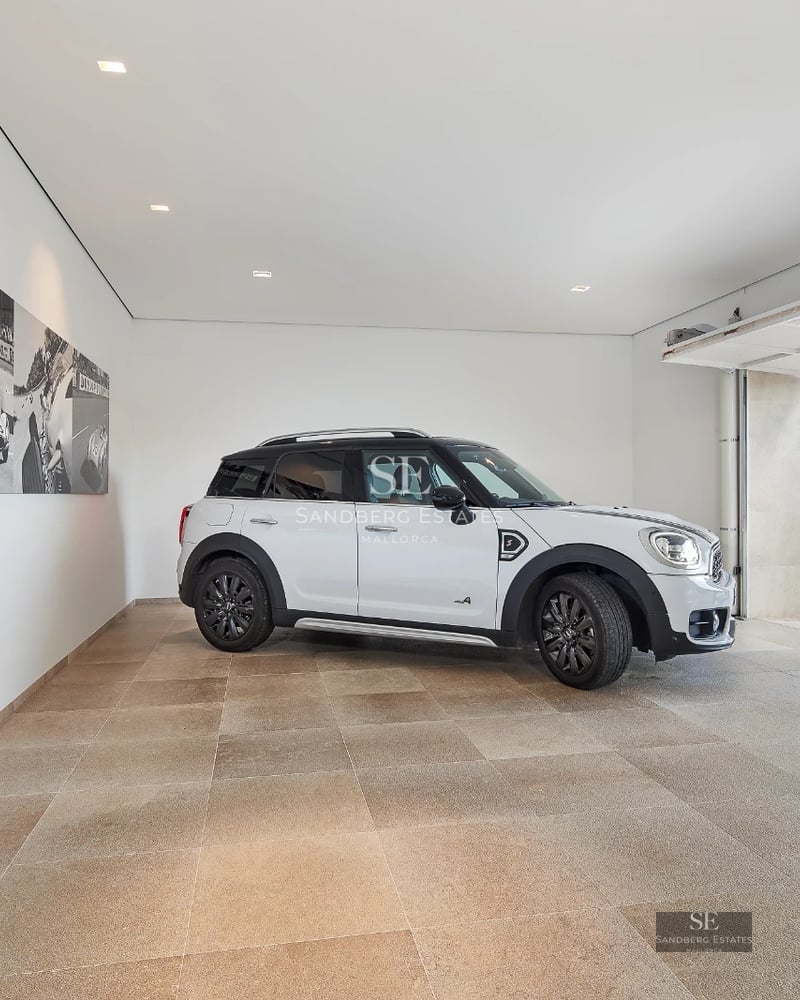 View of infinity pool with terrace, sun loungers, and lush vegetation. Modern architecture with large windows.