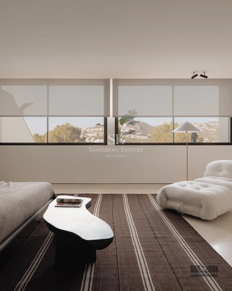 Spacious living room with floor-to-ceiling windows and sea view. Modern design, light wood floors, elegant furniture. Abundant natural light.